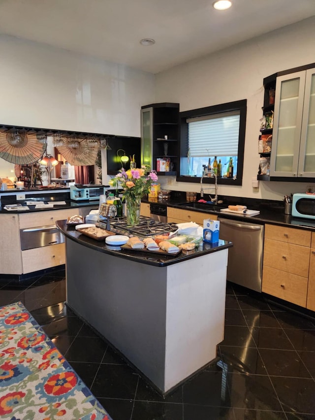 kitchen with a center island, dishwasher, dark tile patterned floors, and sink