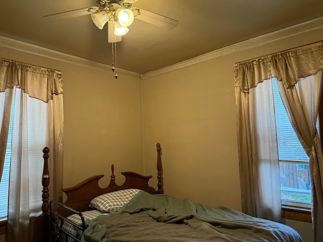 bedroom featuring multiple windows, ornamental molding, and ceiling fan