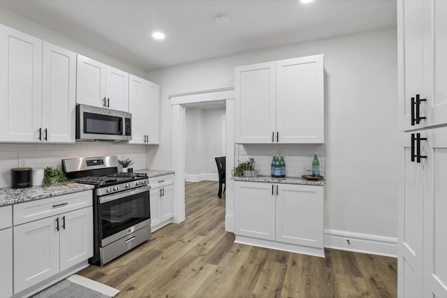 kitchen with white cabinets and appliances with stainless steel finishes