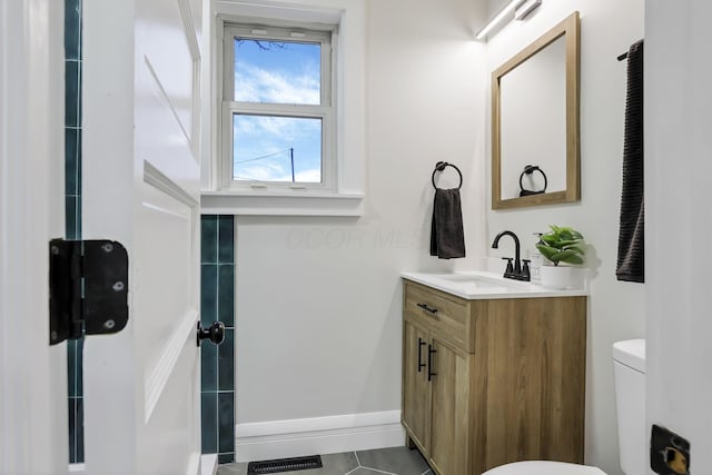 bathroom featuring tile patterned floors, vanity, and toilet