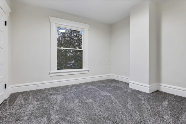 spare room featuring dark carpet