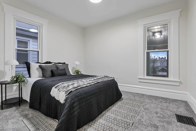 carpeted bedroom with multiple windows