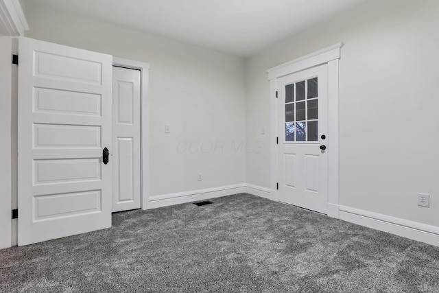 spare room featuring dark carpet