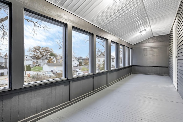 unfurnished sunroom featuring vaulted ceiling and a healthy amount of sunlight