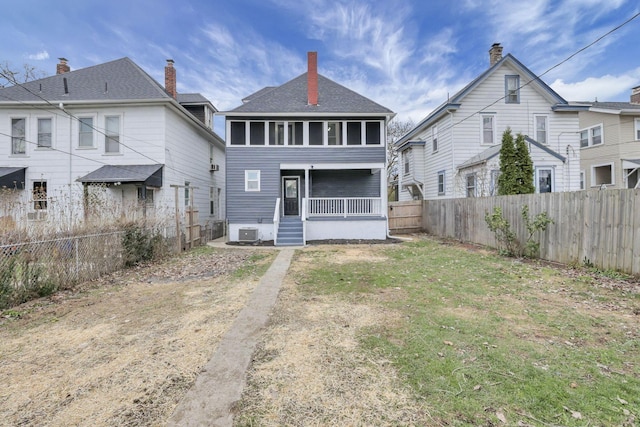 back of house featuring a sunroom and central AC unit