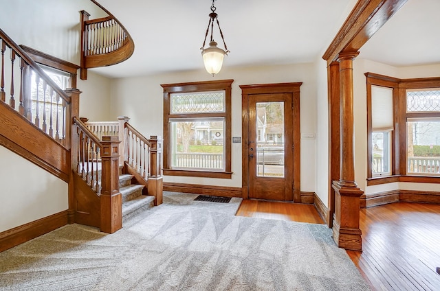 entryway with ornate columns and light hardwood / wood-style flooring