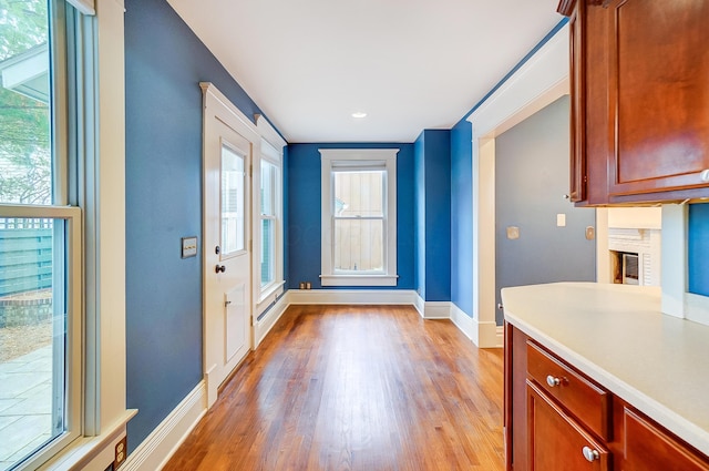 doorway to outside with light hardwood / wood-style flooring and a healthy amount of sunlight