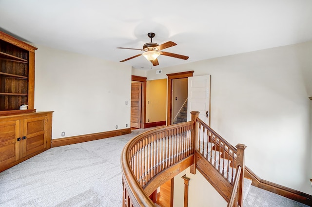 staircase with carpet flooring and ceiling fan