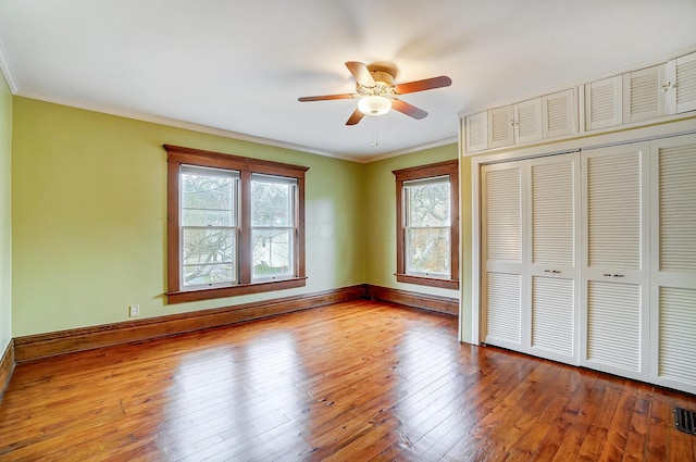 unfurnished bedroom featuring a closet, ceiling fan, light hardwood / wood-style flooring, and ornamental molding