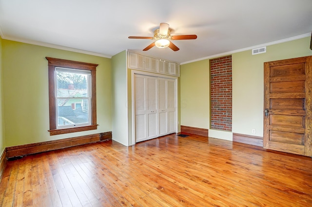 unfurnished bedroom featuring ceiling fan, a baseboard heating unit, light hardwood / wood-style floors, a closet, and ornamental molding