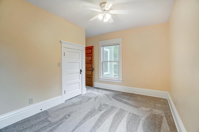 unfurnished room with ceiling fan and carpet