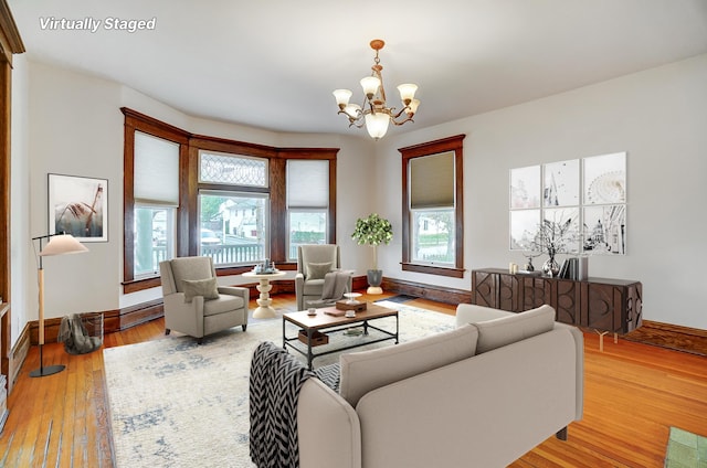 living room featuring light hardwood / wood-style flooring and an inviting chandelier