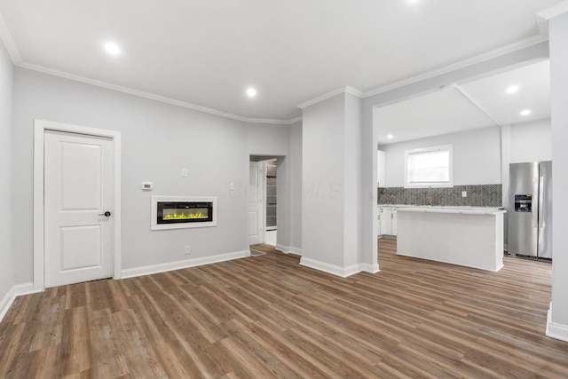 unfurnished living room with crown molding and hardwood / wood-style floors