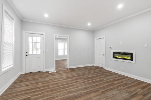 foyer entrance with crown molding and dark hardwood / wood-style flooring