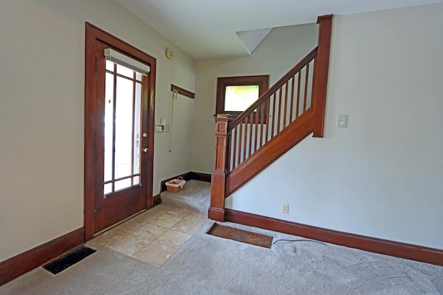 entryway featuring plenty of natural light and light colored carpet