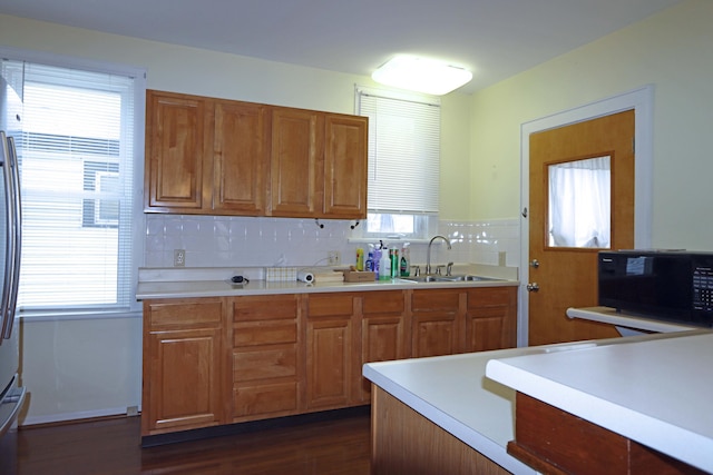 kitchen with plenty of natural light, sink, dark wood-type flooring, and tasteful backsplash