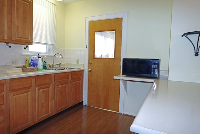 kitchen featuring decorative backsplash, dark hardwood / wood-style flooring, and sink