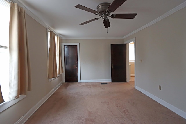 empty room with light colored carpet, ceiling fan, and crown molding