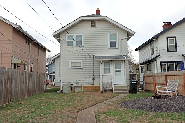 back of house featuring a yard and central AC unit