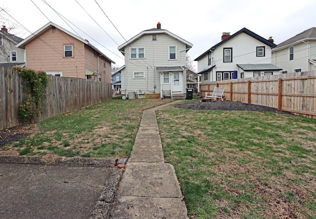 back of house with a lawn