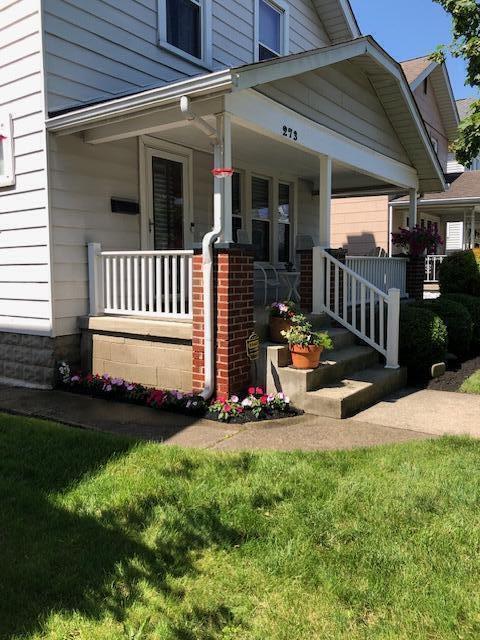 view of exterior entry with covered porch and a yard