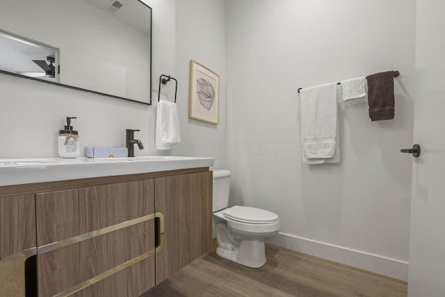 bathroom with vanity, hardwood / wood-style flooring, and toilet