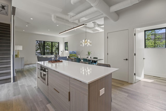 kitchen with a kitchen island, a healthy amount of sunlight, and light hardwood / wood-style floors