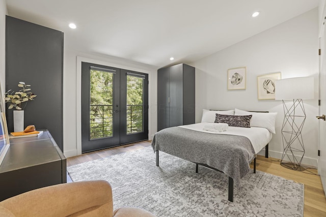 bedroom featuring lofted ceiling, access to exterior, french doors, and light hardwood / wood-style flooring