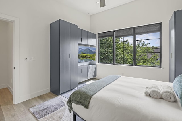 bedroom with light hardwood / wood-style flooring and ceiling fan