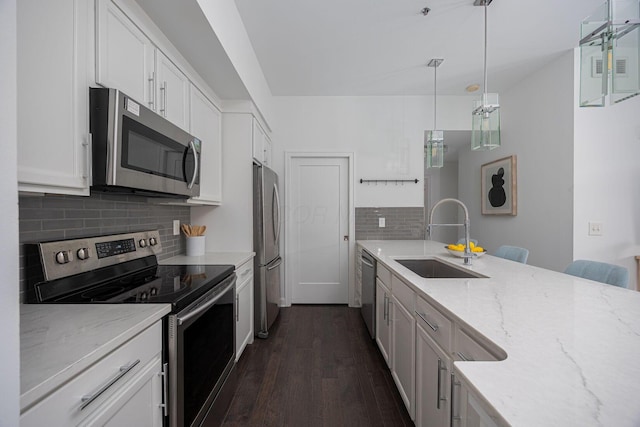 kitchen featuring pendant lighting, appliances with stainless steel finishes, sink, and white cabinets