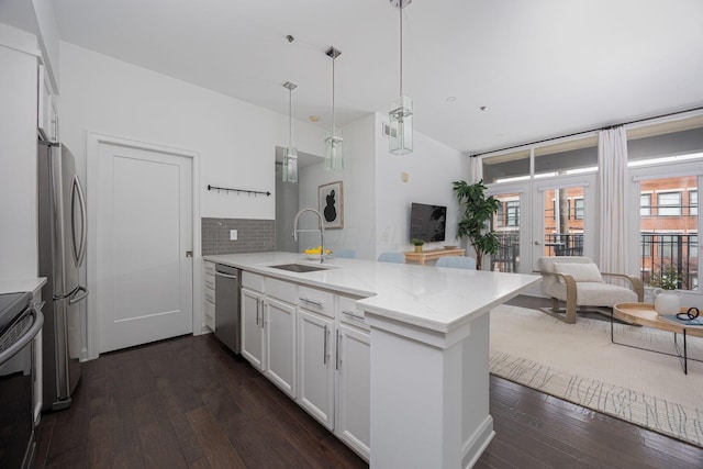 kitchen with sink, stainless steel appliances, kitchen peninsula, and white cabinets