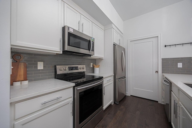 kitchen with light stone counters, appliances with stainless steel finishes, dark hardwood / wood-style flooring, and white cabinets