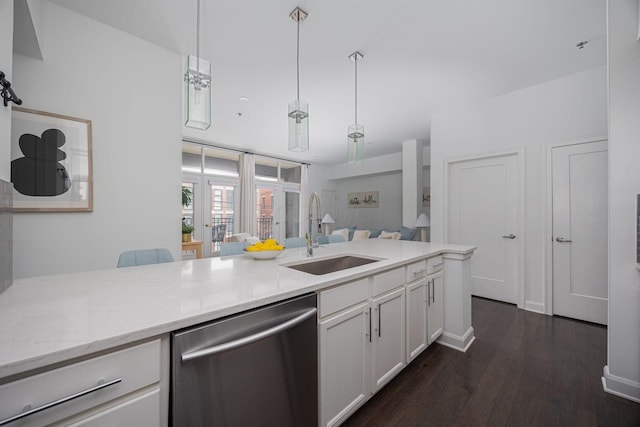 kitchen featuring dark wood-type flooring, sink, white cabinetry, hanging light fixtures, and stainless steel dishwasher