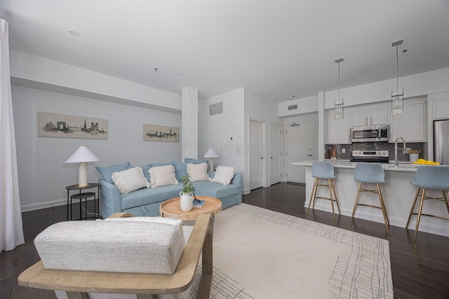 living room with dark hardwood / wood-style floors and sink