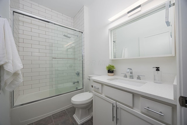 full bathroom featuring vanity, tile patterned flooring, shower / bath combination with glass door, and toilet