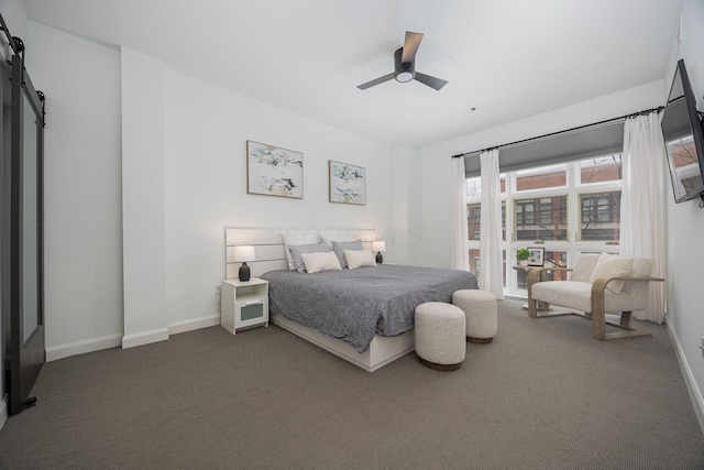 bedroom featuring ceiling fan, a barn door, and carpet