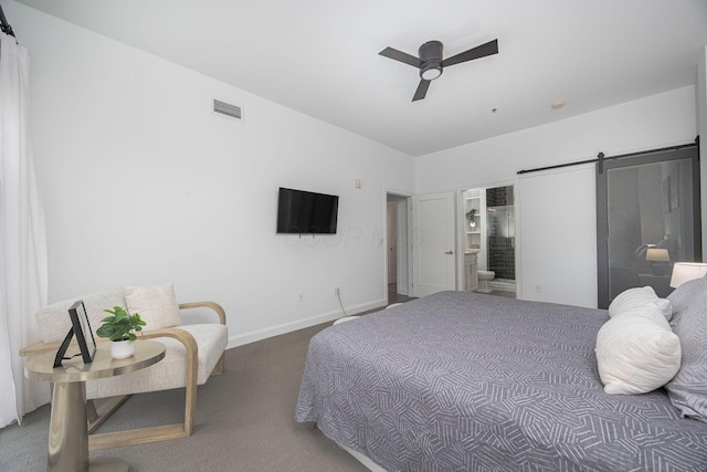 carpeted bedroom featuring ceiling fan, ensuite bathroom, and a barn door