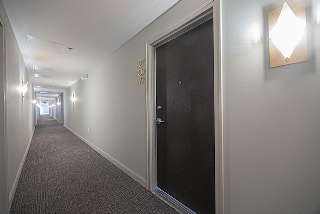 hallway featuring dark colored carpet