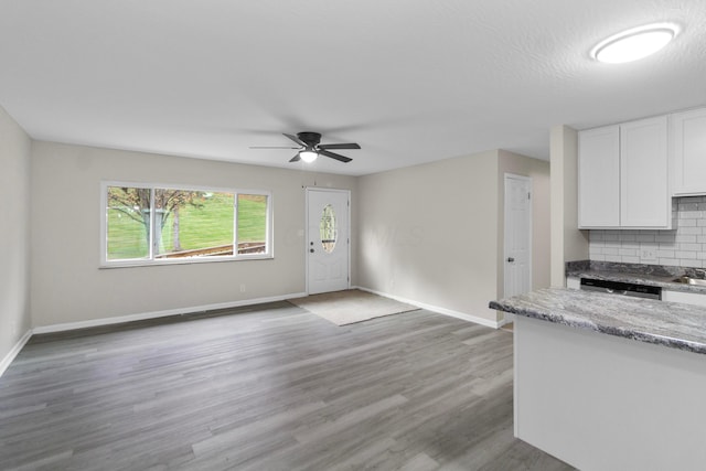 unfurnished living room with ceiling fan, wood-type flooring, and a textured ceiling