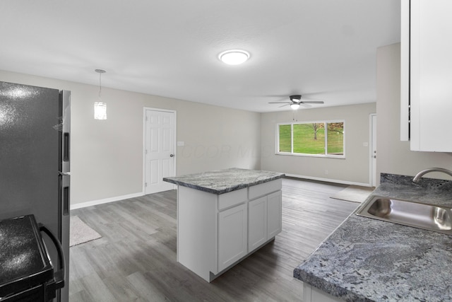 kitchen with dark hardwood / wood-style floors, white cabinetry, sink, and hanging light fixtures