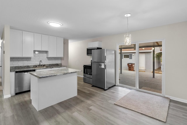 kitchen with sink, stainless steel appliances, light hardwood / wood-style flooring, pendant lighting, and white cabinets