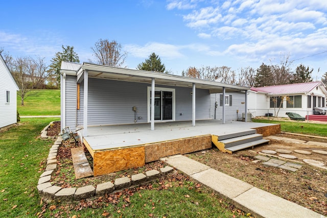 rear view of property featuring a yard