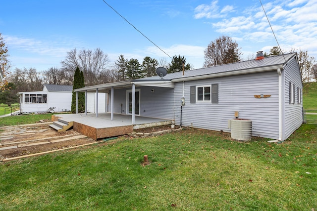 rear view of property featuring central AC unit, a patio area, a yard, and a wooden deck