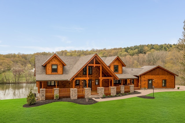 rear view of property with a lawn and a water view