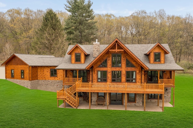 rear view of property with a lawn, a patio area, and a deck