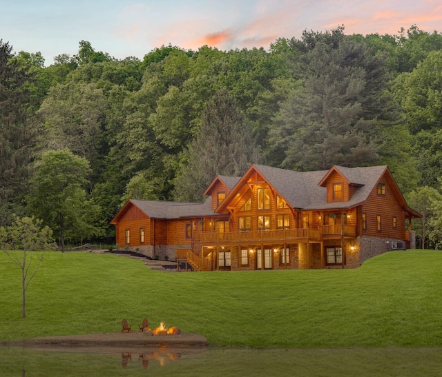 back house at dusk with a yard and a wooden deck