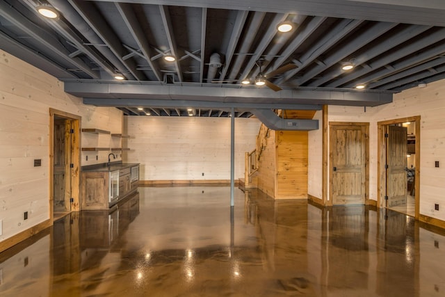 basement featuring wooden walls and sink