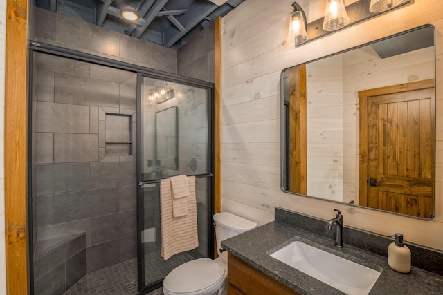 bathroom with vanity, toilet, an enclosed shower, and wooden walls