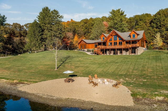 back of property featuring an outdoor fire pit, a lawn, and a wooden deck