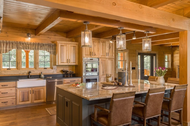 kitchen with stainless steel appliances, a kitchen island, a wealth of natural light, and wooden walls